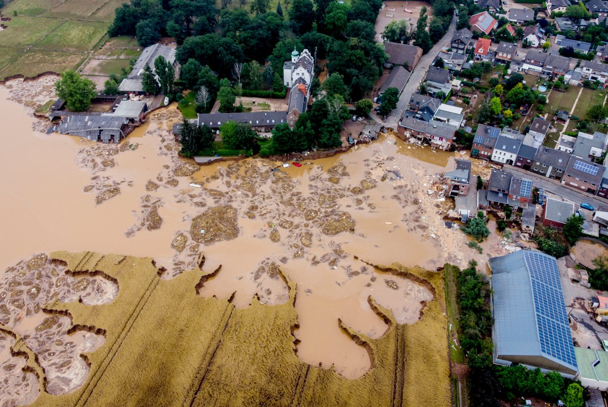 Überflutete Straße in Erftstadt-Blessem nach starken Regenfällen – das Haus der Zahngesundheit Köln unterstützt Flutopfer mit Spenden und Hilfe.