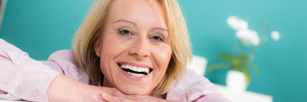 Lächelnde Frau nach ganzheitlicher Parodontose-Behandlung im Haus der Zahngesundheit Köln