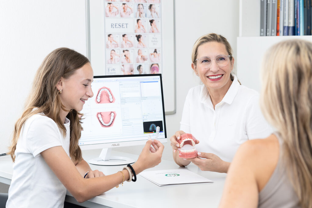 Dr. Paula Göser im Beratungsgespräch mit Mutter und Kind zur ganzheitlichen Kieferorthopädie im Haus der Zahngesundheit Köln