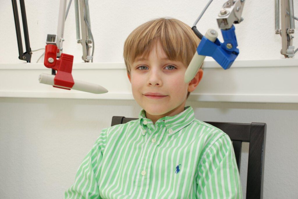 Kleiner Junge während Magnetfeldtherapie – begleitende Behandlung zur ganzheitlichen Kieferorthopädie bei Dr. Paula Göser im Haus der Zahngesundheit Köln